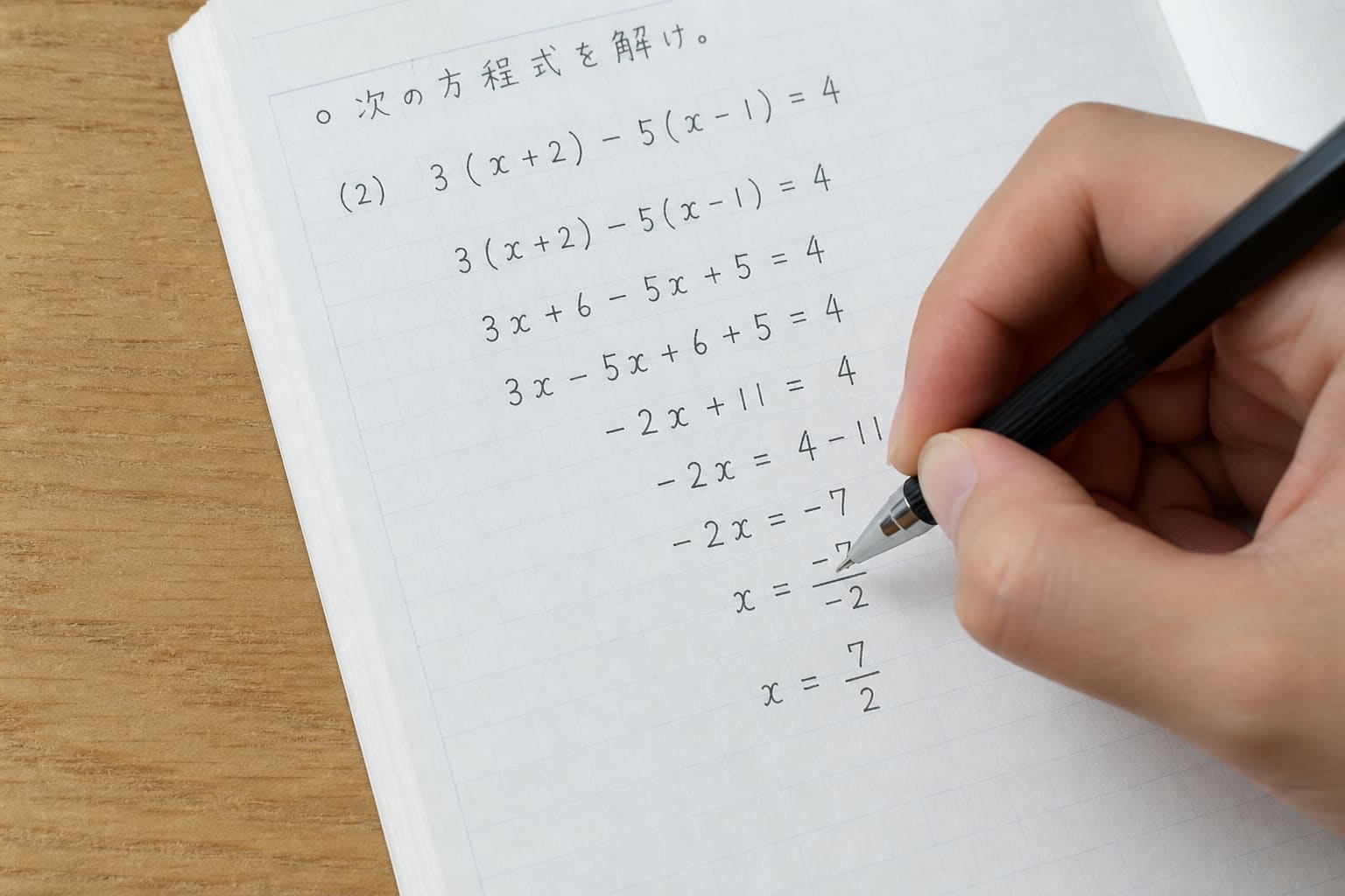 ノートに途中式を書く手元